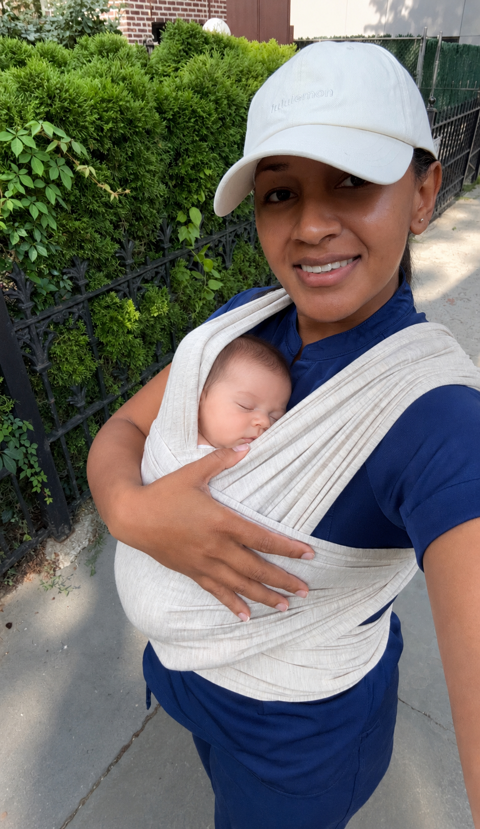 Peterlyn with baby in a carrier outdoors