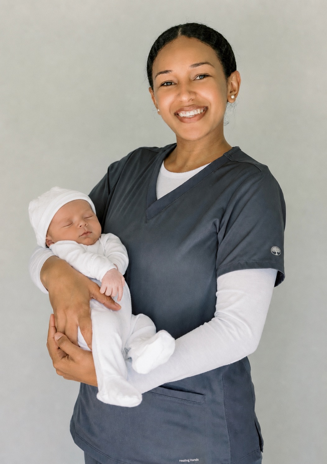 Peterlyn, Certified Newborn Care Specialist, holding a newborn