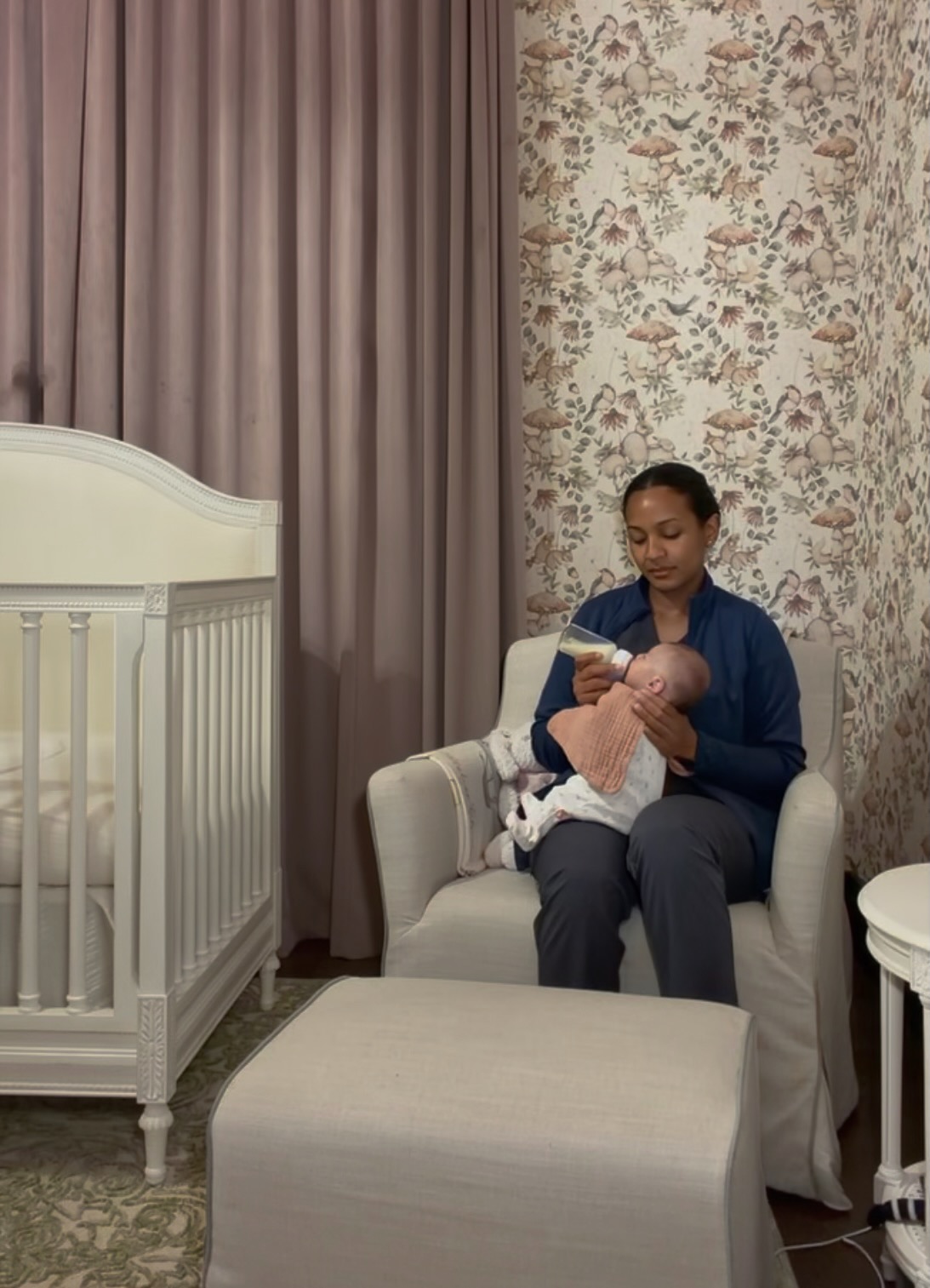 Peterlyn bottle feeding a newborn in a nursery